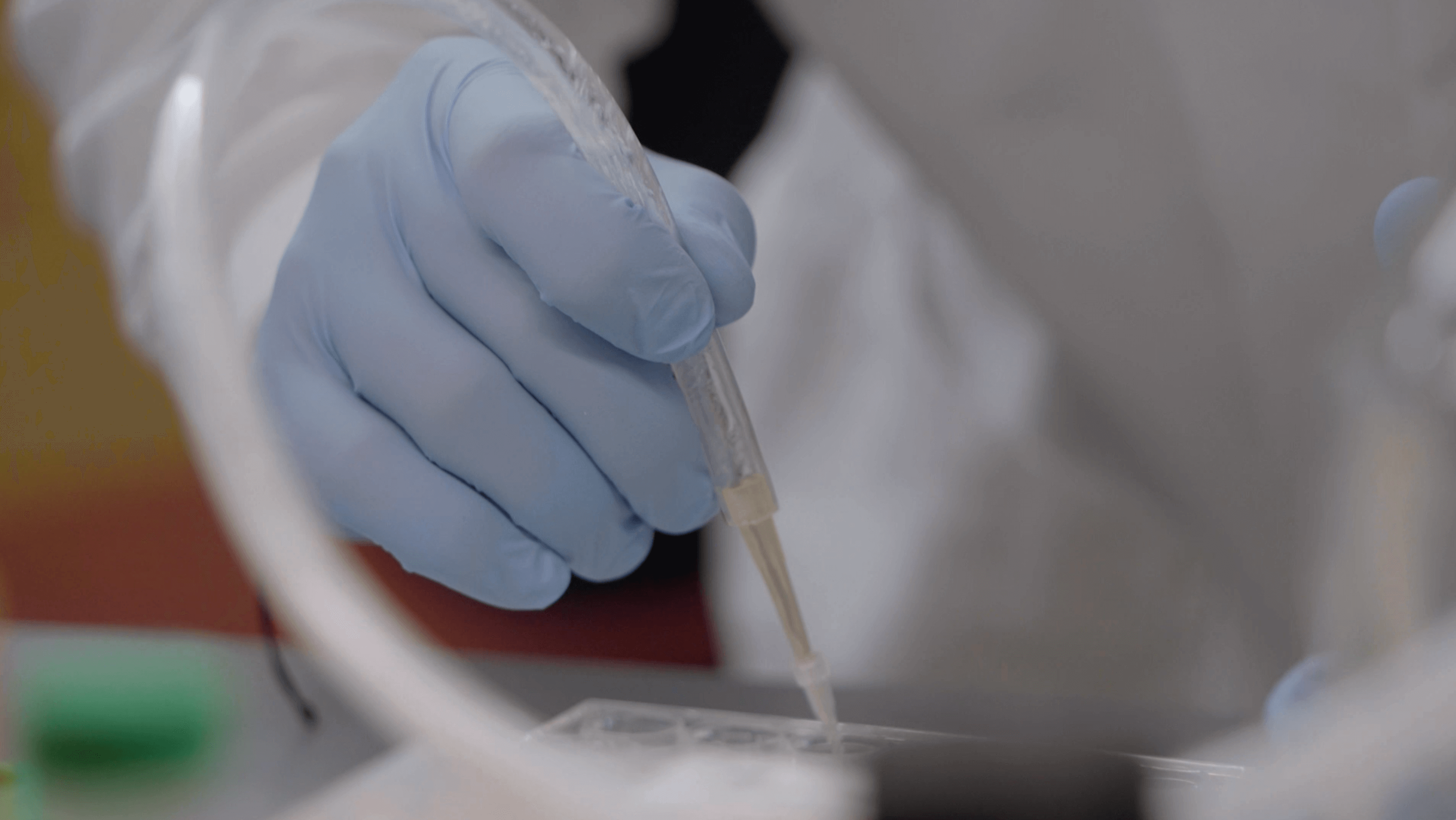 Lab worker using a dropper.